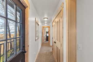 Hall featuring light colored carpet and baseboards