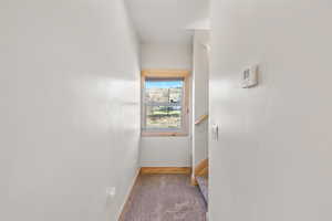 Hallway featuring carpet flooring and baseboards