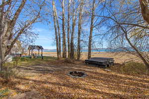 View of yard with an outdoor fire pit and a patio area