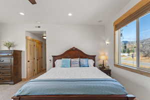 Bedroom featuring recessed lighting, a closet, a ceiling fan, light carpet, and a mountain view