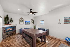 Dining space with a stone fireplace, light wood-type flooring, ceiling fan, and recessed lighting
