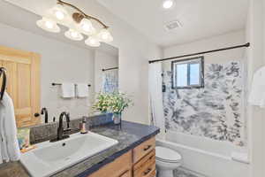 Bathroom with shower / tub combo, vanity, recessed lighting, and a chandelier
