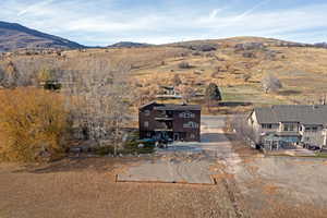 Aerial view of property and surrounding area with a mountainous background