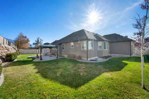 Rear view of house featuring a gazebo, a patio, a fenced backyard, stucco siding, and roof with shingles