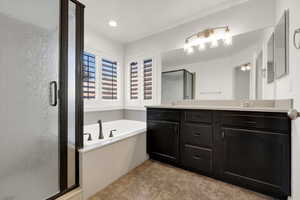 Bathroom with a garden tub, a shower stall, double vanity, light tile patterned flooring, and recessed lighting