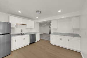 Kitchen featuring stainless steel appliances, white cabinetry, recessed lighting, and light wood finished floors