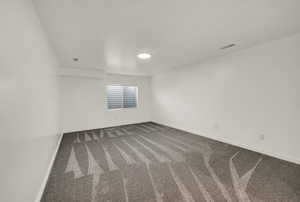 Carpeted empty room with baseboards