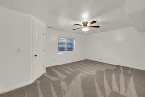Empty room featuring light colored carpet and a ceiling fan