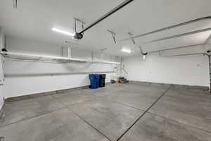 Garage featuring baseboards and a garage door opener