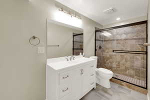 Full bath featuring vanity, a shower stall, and recessed lighting