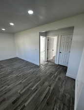 Unfurnished room with a textured ceiling, dark wood-style floors, and recessed lighting