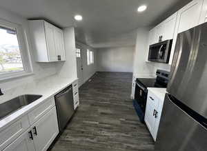 Kitchen featuring stainless steel appliances, white cabinets, a textured ceiling, dark wood finished floors, and recessed lighting