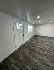 Entryway with a textured ceiling, dark wood finished floors, and recessed lighting