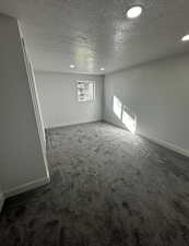 Empty room featuring a textured ceiling, carpet floors, and recessed lighting