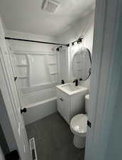 Bathroom featuring a textured ceiling, vanity, dark tile patterned floors, and shower / bath combination