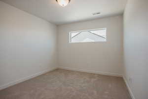 Unfurnished room featuring light carpet and baseboards