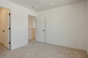 Unfurnished bedroom with baseboards and light carpet