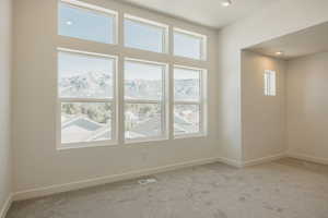 Carpeted spare room with baseboards and recessed lighting