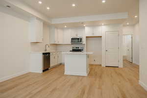 Kitchen with white cabinetry, recessed lighting, a center island, and appliances with stainless steel finishes
