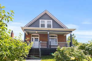 View of front of house featuring a porch and brick siding