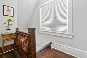 Stairway featuring hardwood / wood-style flooring and lofted ceiling