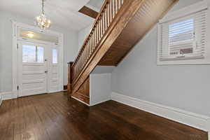 Entrance foyer featuring plenty of natural light, dark wood finished floors, and hanging lights