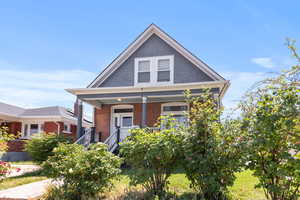 View of front facade with covered porch and a front yard