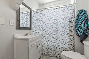 Full bath featuring vanity, curtained shower, and light tile patterned floors