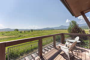 Wooden terrace featuring a view of countryside and a mountain view