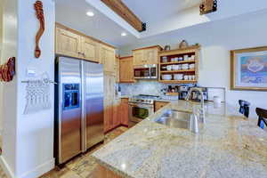 Kitchen featuring tasteful backsplash, open shelves, appliances with stainless steel finishes, recessed lighting, and light stone countertops