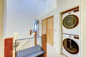 Laundry area featuring estacked washer and dryer and baseboards