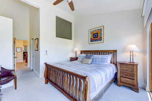 Bedroom with light carpet and a ceiling fan