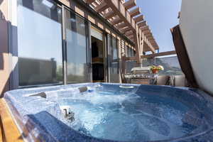 View of patio / terrace featuring a hot tub and a pergola