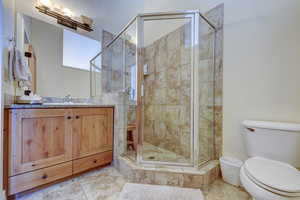 Bathroom with vanity, a stall shower, and tile patterned floors