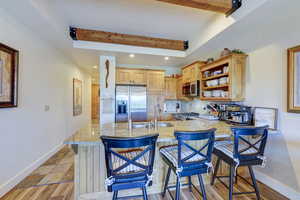 Kitchen with recessed lighting, a kitchen breakfast bar, decorative backsplash, stainless steel appliances, and open shelves