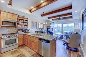 Kitchen with recessed lighting, open shelves, stainless steel appliances, a peninsula, and beam ceiling