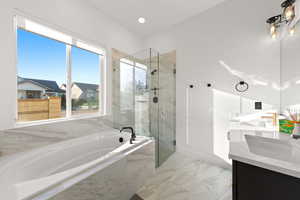 Bathroom with double vanity, light marble finish floors, a marble finish shower, a bath, and recessed lighting