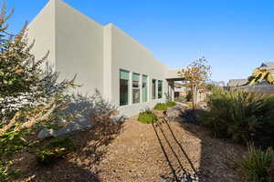 Rear view of house with stucco siding and a patio
