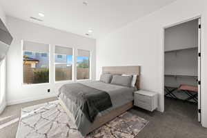 Bedroom with carpet flooring, a walk in closet, and recessed lighting
