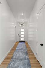 Entrance foyer featuring a chandelier, light wood finished floors, and recessed lighting