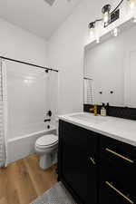 Full bath featuring light wood-style flooring, vanity, and shower / bath combo with shower curtain