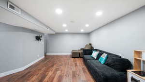 Living area with wood finished floors and recessed lighting