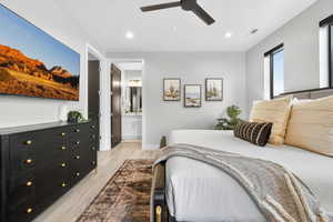 Bedroom featuring light wood-style flooring, recessed lighting, ensuite bath, and a ceiling fan