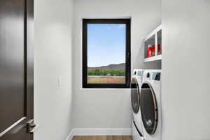 Washroom featuring independent washer and dryer and light wood-type flooring