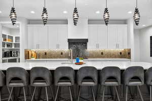 Kitchen featuring pendant lighting, white cabinetry, decorative backsplash, recessed lighting, and a large island