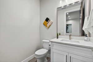 Bathroom with vanity, dark wood finished floors, and recessed lighting