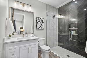 Ensuite bathroom with vanity and a marble finish shower