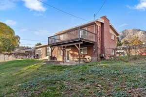 Back of property with a chimney, a patio, and brick siding