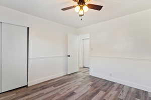 Bedroom featuring wood finished floors, ceiling fan, and a closet