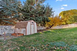 View of shed with a fenced backyard and a garden